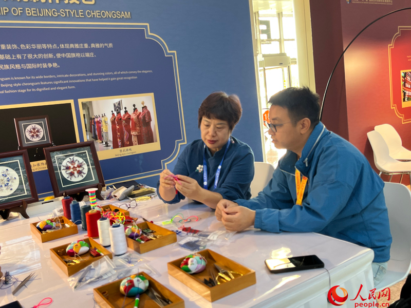 プレスセンターの無形文化遺産伝承者展示エリアで體験する記者（撮影?杜燕飛）。