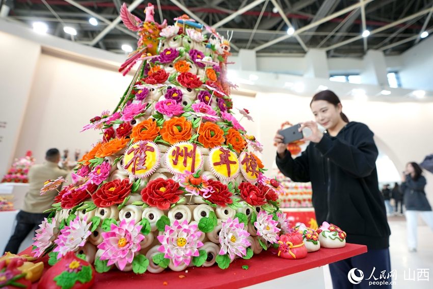    山西省の麺塑作品で年越しの際に作られる「霍州年饃」を撮影する來場者（撮影?盧鵬宇）。