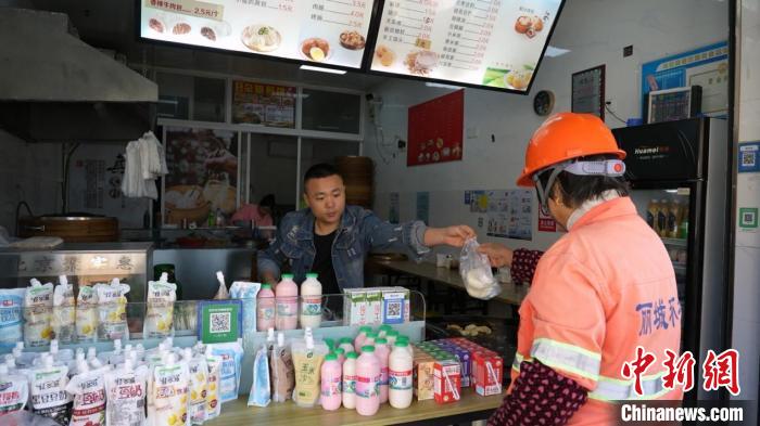 清掃員に包子を渡す郭慶順さん（撮影?劉建東）。