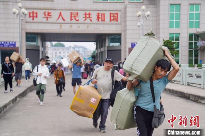 日用品などを擔(dān)いで運(yùn)ぶ人々で賑わう中國(guó)とベトナムの國(guó)境の街