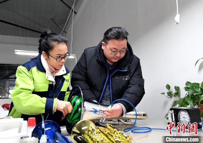 19日、樹脂製楽器の気密性をチェックする作業(yè)員。撮影?賈梟夢