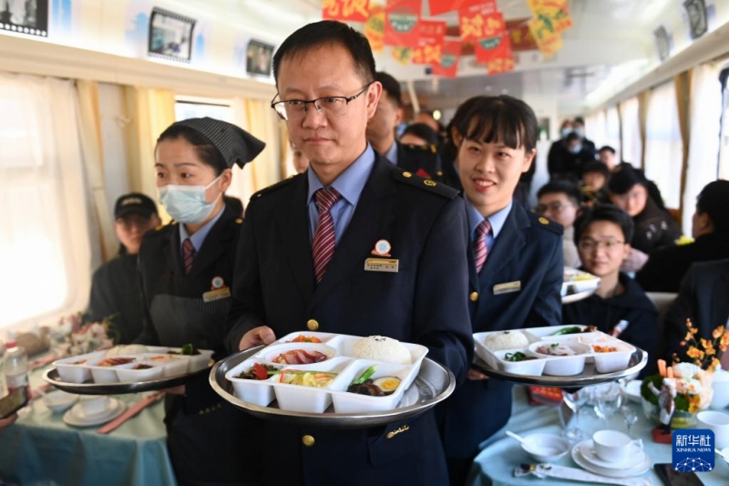 K212/209號(hào)の車(chē)內(nèi)で、定食弁當(dāng)を見(jiàn)せる乗務(wù)員（1月17日撮影?黃宗治）。