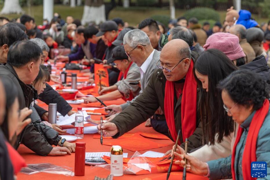 重慶市永川區(qū)で行われた書道関連イベントの會(huì)場(chǎng)では、地元の書家や民間文蕓家、複數(shù)の學(xué)校の教員?學(xué)生が、春聯(lián)（春節(jié)に家の玄関などに貼る縁起の良い対句が書かれた赤い紙）や切り紙の制作を行い、一般市民に無料で配布（1月18日撮影?黃偉）。