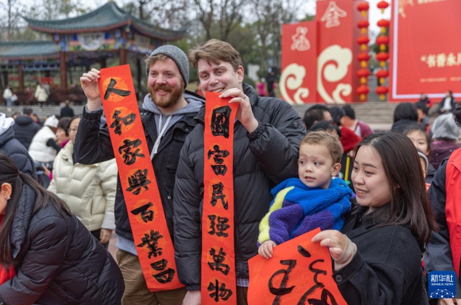 もらった春聯(lián)（春節(jié)に家の玄関などに貼る縁起の良い対句が書かれた赤い紙）を見せる子供たち（撮影?黃偉）。