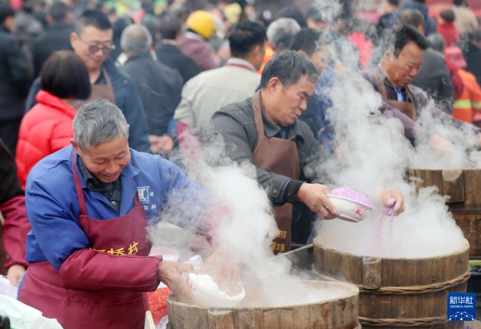 浙江省湖州市徳清県禹越鎮(zhèn)高橋村で開催された「第3回年高（糕）文化フェスティバル」で、年糕（春節(jié)に食べる餅）をつき、餅粉を作り、パフォーマンスを鑑賞し、江南水郷の民俗風(fēng)情をともに味わう村民と観光客（1月18日撮影?謝尚國(guó)）。