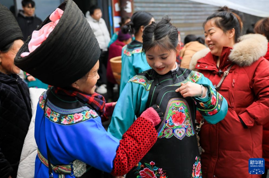 湖南省湘西土家（トゥチャ）族苗（ミャオ）族自治州鳳凰県山江鎮(zhèn)の市場(chǎng)で、苗族の民族衣裝を購(gòu)入する女性（1月18日撮影?張鋮）。