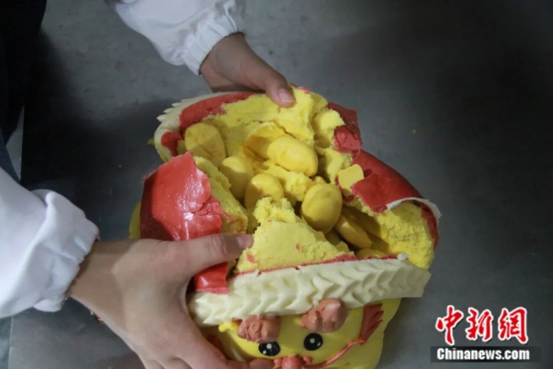 豊かさを示す金塊「金の元寶」をモチーフにした「花餑餑」。金運(yùn)と幸運(yùn)の願(yuàn)いを込め、なかには小さなサイズの「金の元寶」が8個(gè)入っている（撮影?王宇軒）。