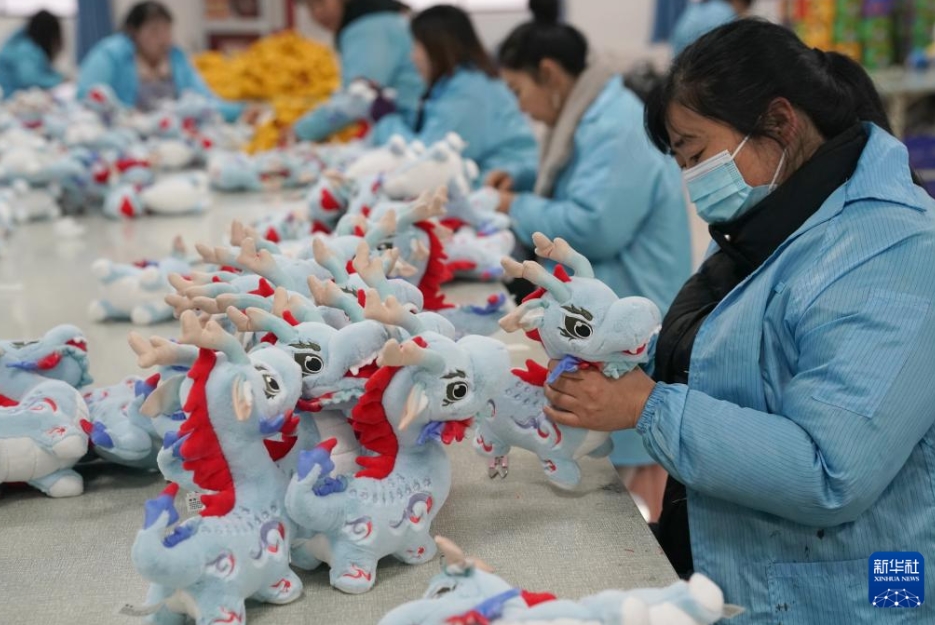 安康愛多寶動(dòng)漫文化産業(yè)有限公司の生産ラインで、干支の竜のぬいぐるみを加工する作業(yè)員（2月20日撮影?邵瑞）。