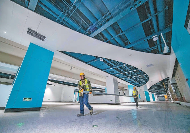 地下鉄12號線では、駅及び駅間の主體構(gòu)造工事が完了している。畫像は三元橋駅の乗換通路の內(nèi)裝工事をする作業(yè)員。撮影?潘之望