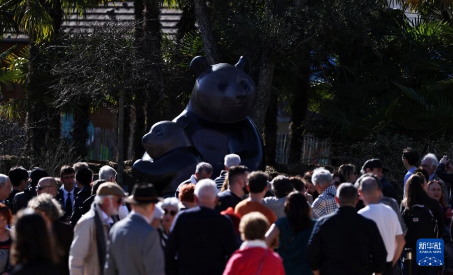 3月22日にお披露目されたパンダのモニュメントを眺める來園者（撮影?高靜）。