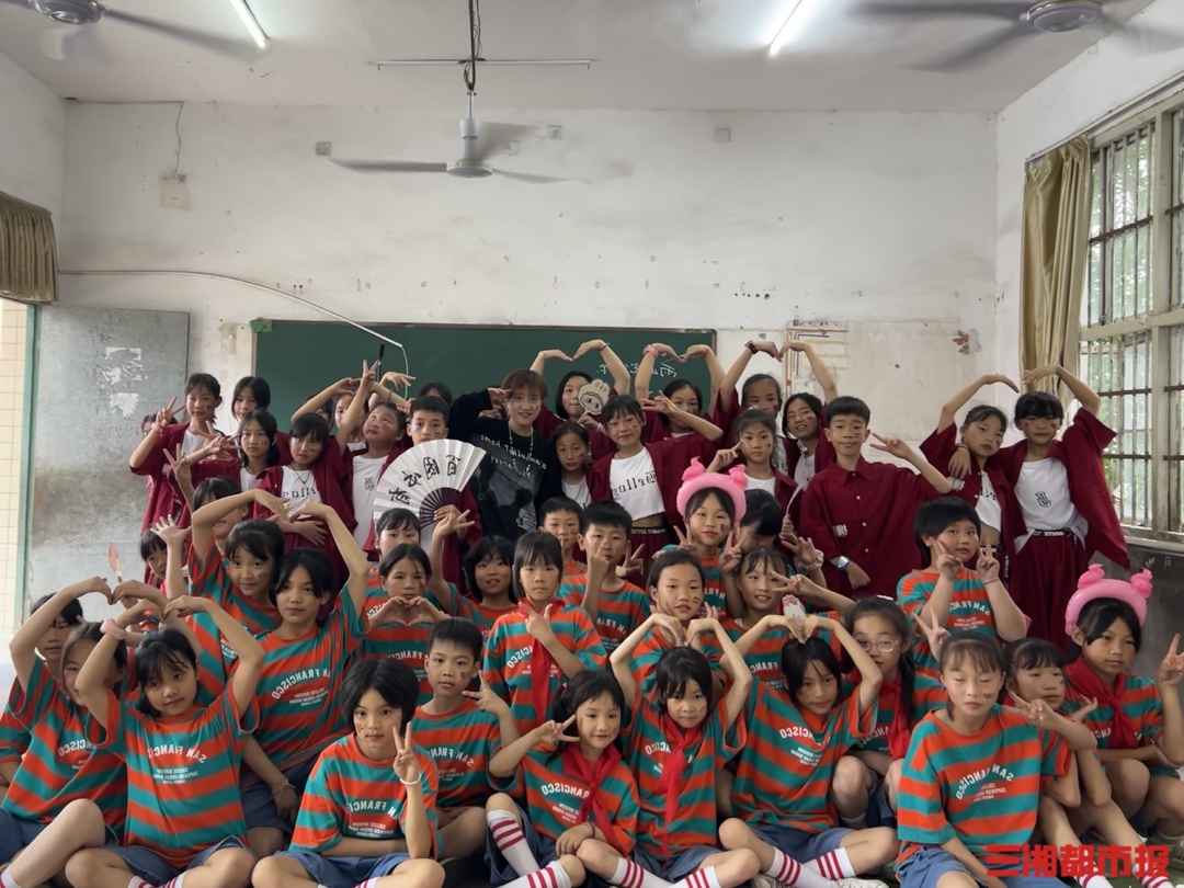 児童と一緒に寫真に寫る夏子然さん（寫真提供?夏さん本人）。