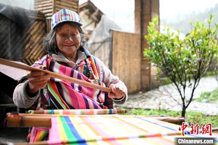 トールン毯を織る顔に刺青を入れたトールン族の女性?太恰さん（撮影?李嘉嫻）。