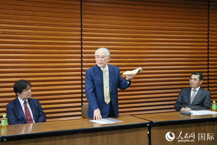 少年期から持っている中國(guó)古典文學(xué)の書籍を見(jiàn)せる日本畫家の藤島博文氏(中央)(撮影?許可)