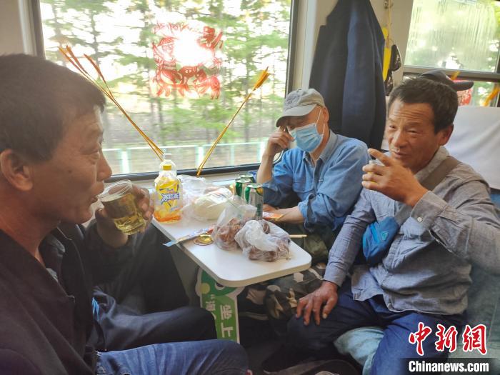 車內(nèi)でビールを飲みながら會(huì)話する男性たち（寫真提供?中國(guó)鉄路哈爾浜局集団有限公司）。