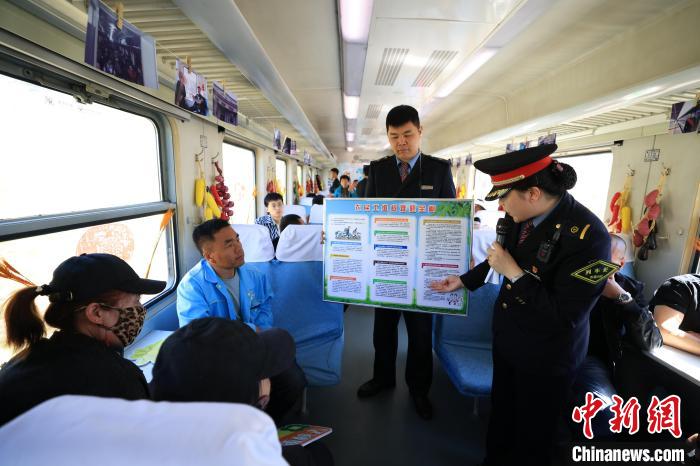 出稼ぎ労働者に法律に関する知識(shí)を紹介する乗務(wù)員（寫真提供?中國(guó)鉄路哈爾浜局集団有限公司）。