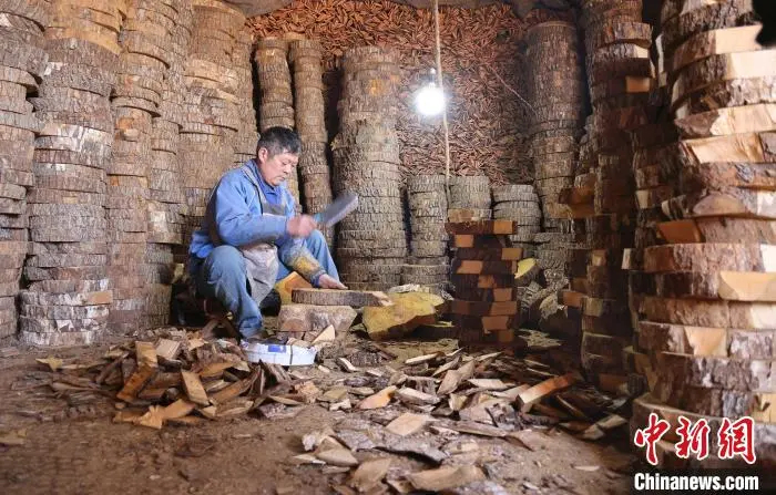 櫛の材料となる木材を加工する男性（撮影?許伝寶）。