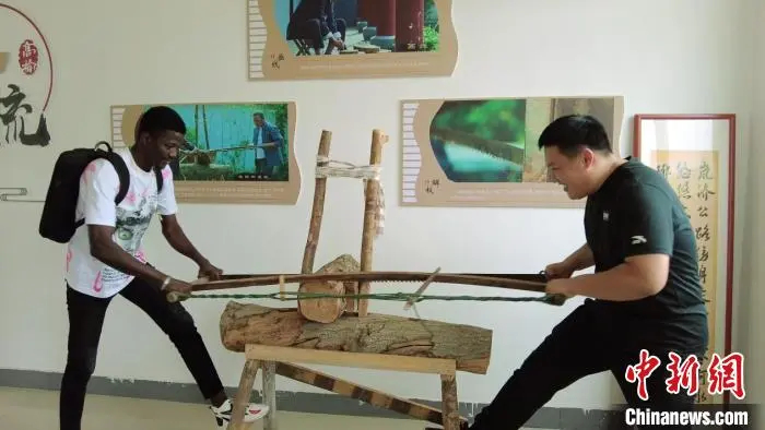 東高楡村の木製の櫛文化を體験するマイクさん（撮影?徐俐莉）。