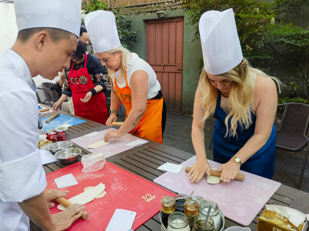 中國のプロのコックの指導(dǎo)を受けながら、生地を伸ばす外國人観光客（5月29日撮影?陳愛平）。