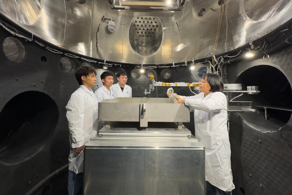 學(xué)生に月面環(huán)境シミュレーターの説明を行う哈爾浜工業(yè)大學(xué)の李麗芳教授（右）（6月1日撮影）。撮影?楊思琪