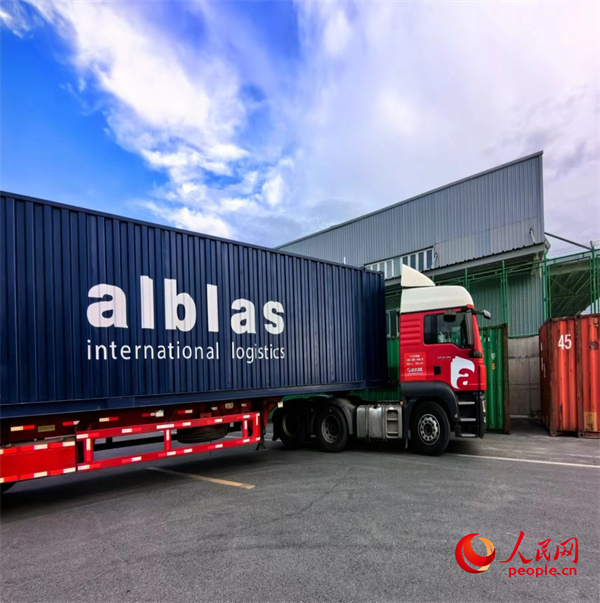 烏魯木斉國際陸港區(qū)をゆっくり走り出るアルブラス運(yùn)輸（新疆）有限公司の貨物輸送トラック。（撮影?韓婷）