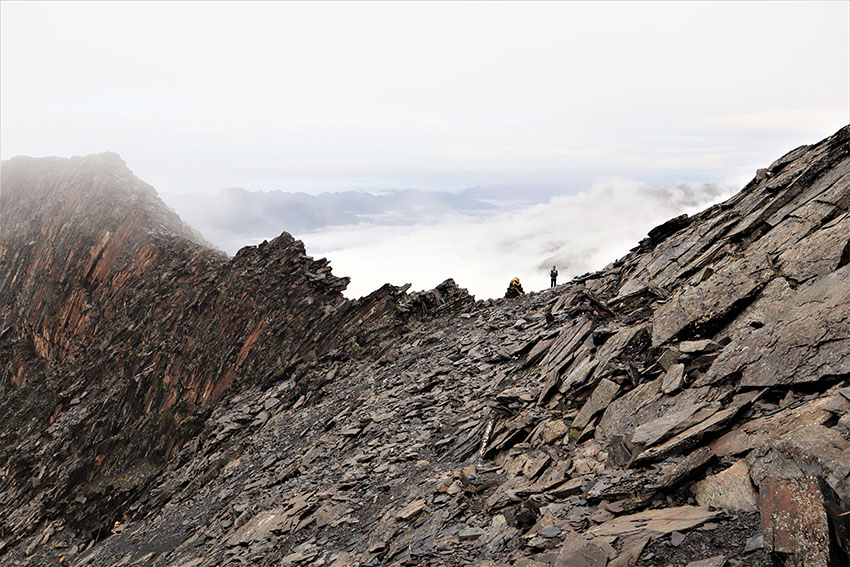 四川省阿壩蔵（アバ?チベット）族羌（チャン）族自治州にある四姑娘山の頂上付近、稜線に浮かぶガイド（撮影 · 和中清）。