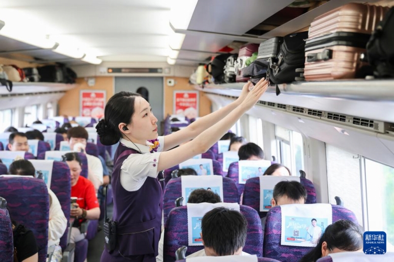 7月15日、高速列車G8389號(hào)內(nèi)で、旅客の荷物を整理する乗務(wù)員。