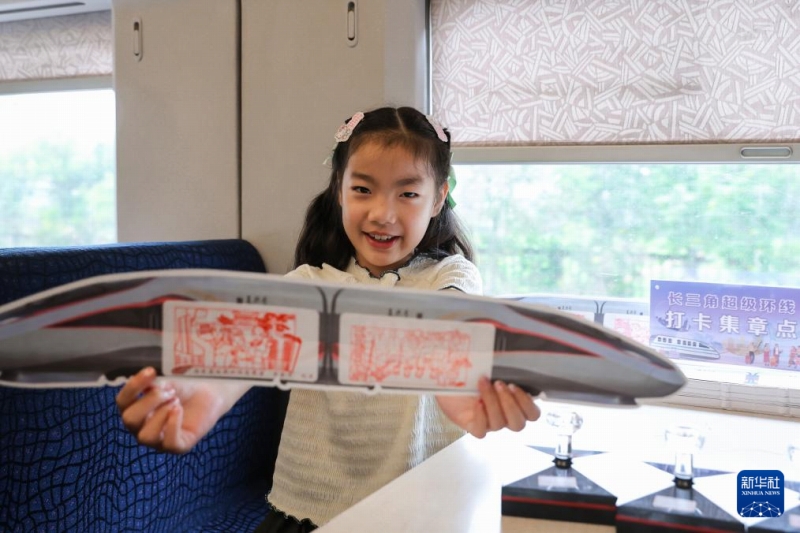 7月15日、高速列車G8389號(hào)內(nèi)で押したスタンプを見せる女の子。