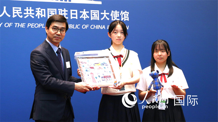 在日本中國大使館の施泳公使にプレゼントを手渡す日本の「小大使」（撮影?許可）。