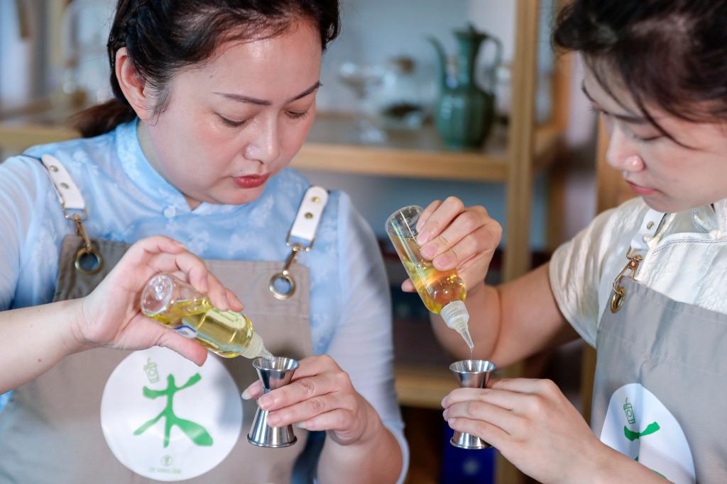 5月23日、學(xué)生に「新中國スタイルのティードリンク」の作り方を教える調(diào)飲師の汪蓀さん（寫真左）。