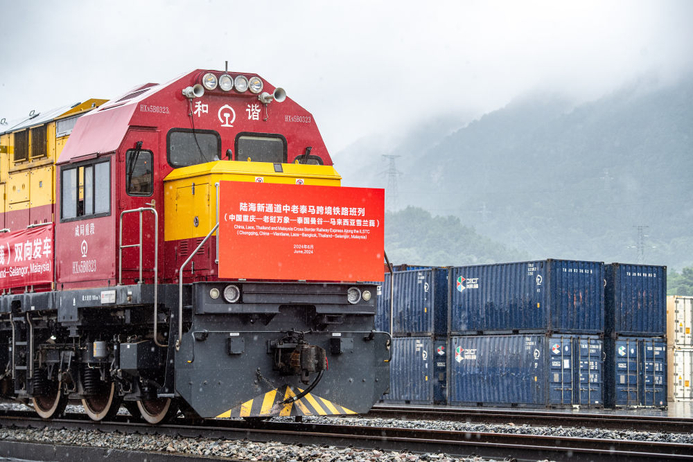西部陸海新ルートで、駅を出発する中國?ラオス?タイ?マレーシアを結ぶシー?アンド?レールの列車。（撮影?唐奕）