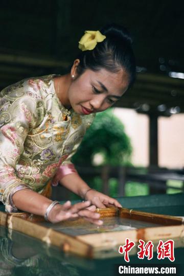 傣族伝統(tǒng)の手漉き紙を作る艾葉さん（撮影?賀?？。?。