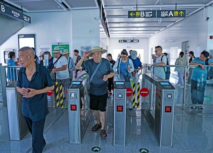 カードをかざして自動(dòng)改札機(jī)を通過(guò)する乗客。