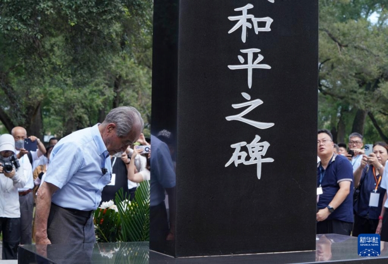 731部隊(duì)跡地にある「謝罪と不戦平和の誓い」と書かれた石碑に向かって頭を下げ、後悔の念と謝罪の気持ちを表す清水英男さん（寫真左、8月13日撮影?王松）。