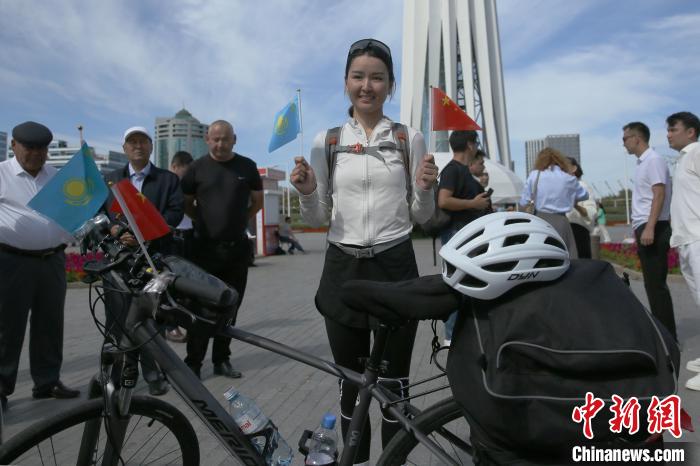 アスタナのランドマークであるモニュメント兼展望塔?バイテレクの前で記念寫真を撮影する布爾蓮さん（撮影?単璐）。