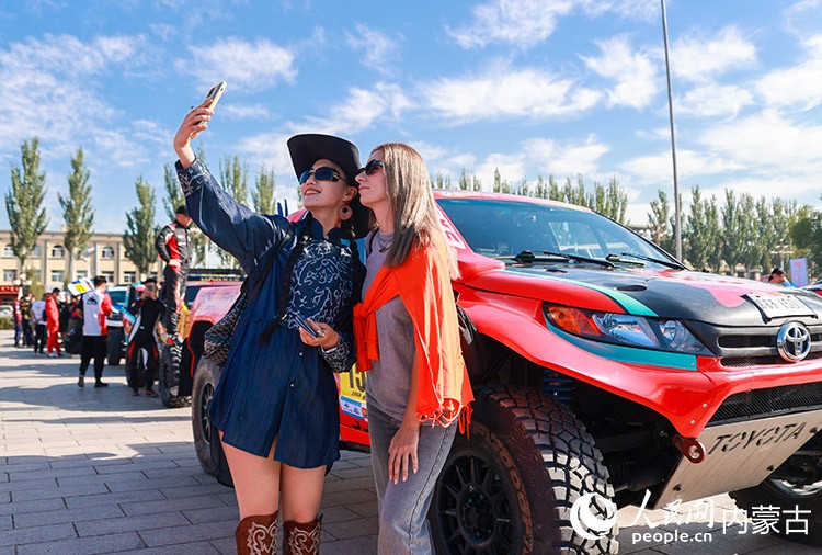 開幕式で記念寫真を撮影する外國人女性（8月22日撮影?丁根厚）。