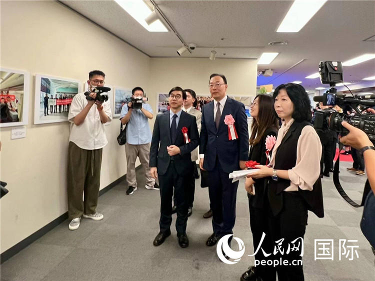 在日本中國(guó)大使館の施泳臨時(shí)代理大使ら來賓に展示寫真を紹介する中國(guó)國(guó)際航空日韓地區(qū)支社の馮力支社長(zhǎng)（撮影?許可）