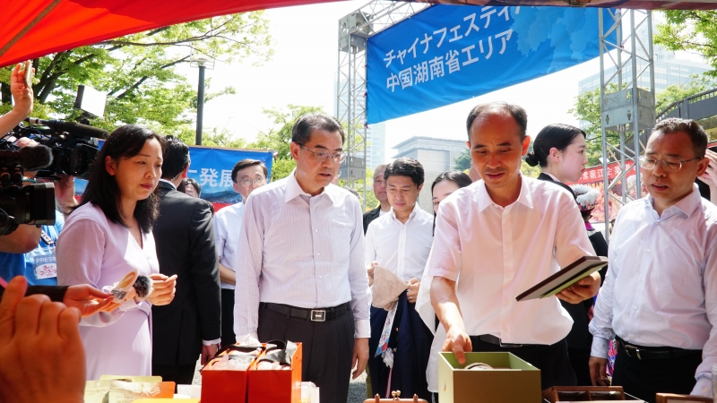 呉江浩駐日大使に特色ある文化クリエイティブグッズを紹介する湖南省エリアのスタッフ（撮影?蔣暁辰）。