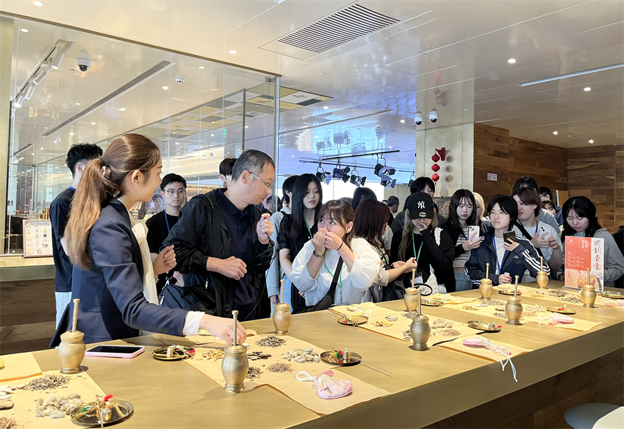 中醫(yī)の香囊作りの手順を?qū)Wぶ日中友好協(xié)會(huì)青年代表団の一行（撮影?陳思）。