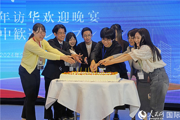 訪(fǎng)中期間中に誕生日を迎えた日本の青年を祝う參加者たち（撮影?張麗婭）。