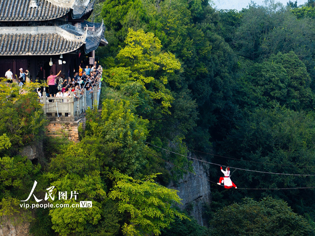 ワイヤーの上を人が渡るアクロバティックなパフォーマンス「鉄索飛渡」ショー（撮影?張波/寫真著作権は人民図片が所有のため転載禁止）。
