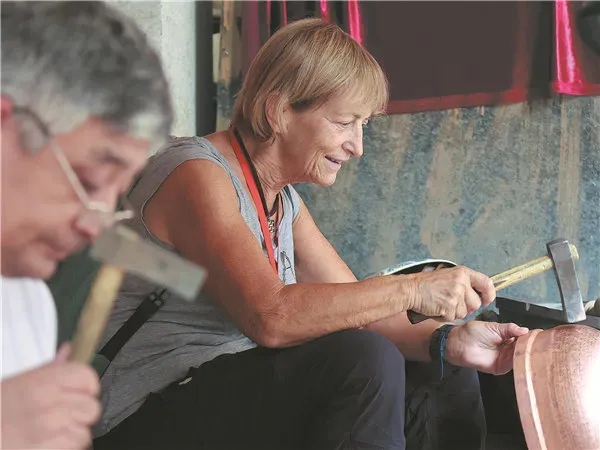 新疆維吾爾（ウイグル）自治區(qū)で、銅器作りを體験するヴィエナ?カンマロータさん。