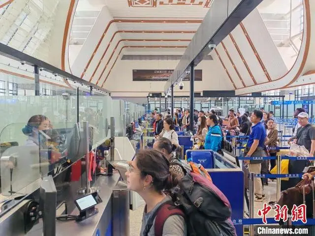 中國(guó)ラオス鉄道が通過(guò)する中國(guó)とラオスの國(guó)境地點(diǎn)にある磨憨出入國(guó)検査所で出入國(guó)手続きをする各國(guó)の旅客たち（9月25日撮影?鍾濤）。