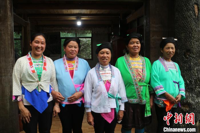 自治區(qū)と省を跨ぐ宿の前で記念撮影をする女性たち。（撮影?陳梅）