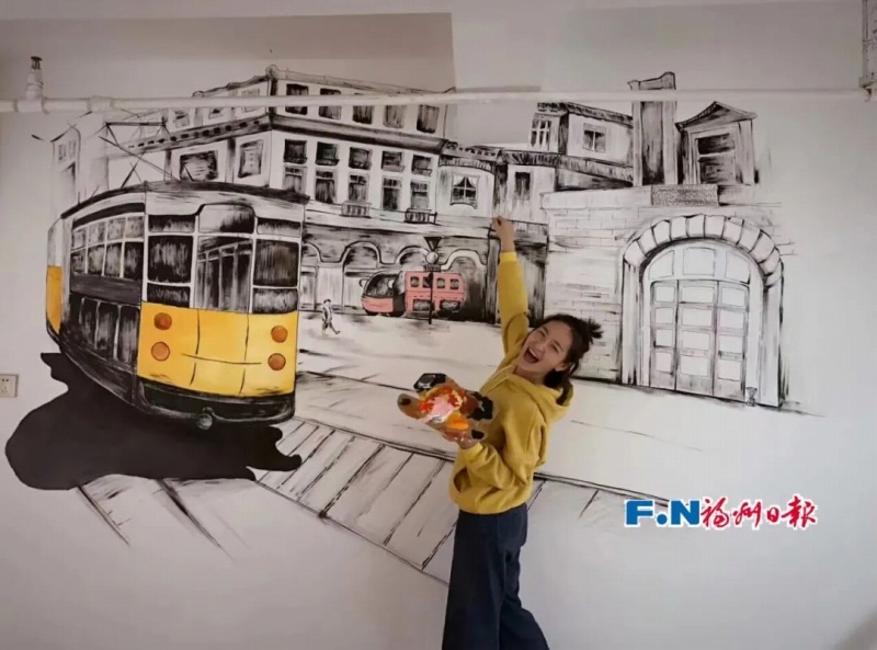 自身が手掛けたウォールアートの前に立つ林小燕さん。