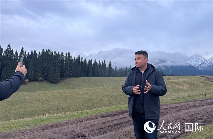 庫(kù)爾徳寧（クエルデニン）景勝地の雪山がある美しい景色に感動(dòng)し、その場(chǎng)でショート動(dòng)畫(huà)を撮影する吾買爾江さん（撮影?曾書(shū)柔）。