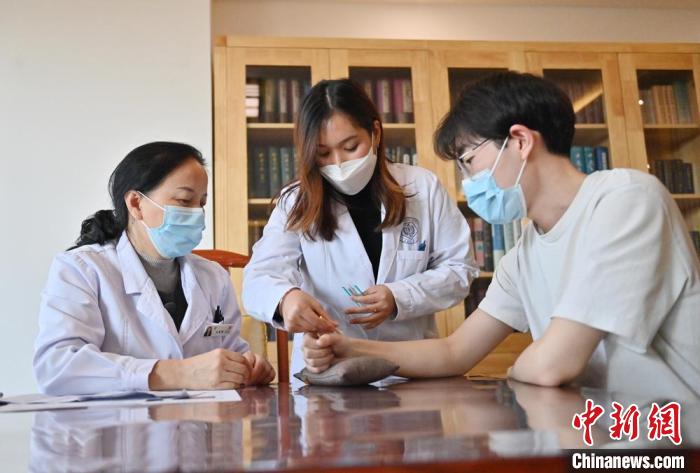 教員の指導(dǎo)の下、鍼灸治療を行う林玉花さん(左から2番目、撮影?張瑤)。