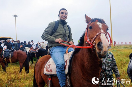 呼和浩特市敕勒川草原で乗馬體験をするイスラムさん。（撮影?張雪冬）