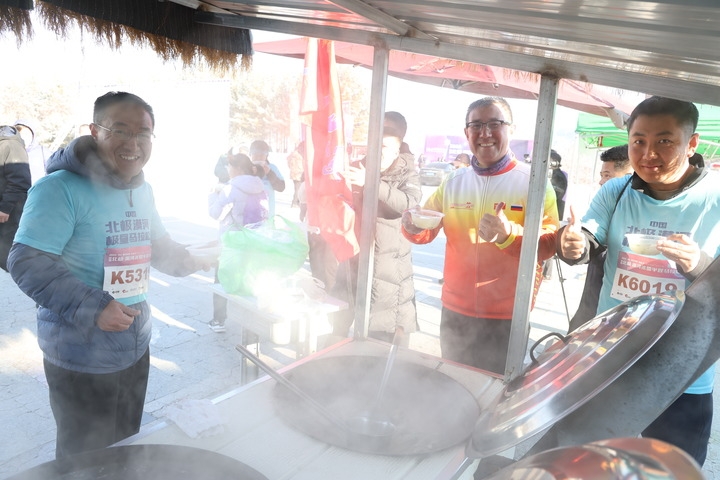 黒竜江省漠河市北極村で開催されたハーフマラソン大會で、エイドステーションに用意されたご當(dāng)?shù)廿哎毳幛驑Sしむランナーら。