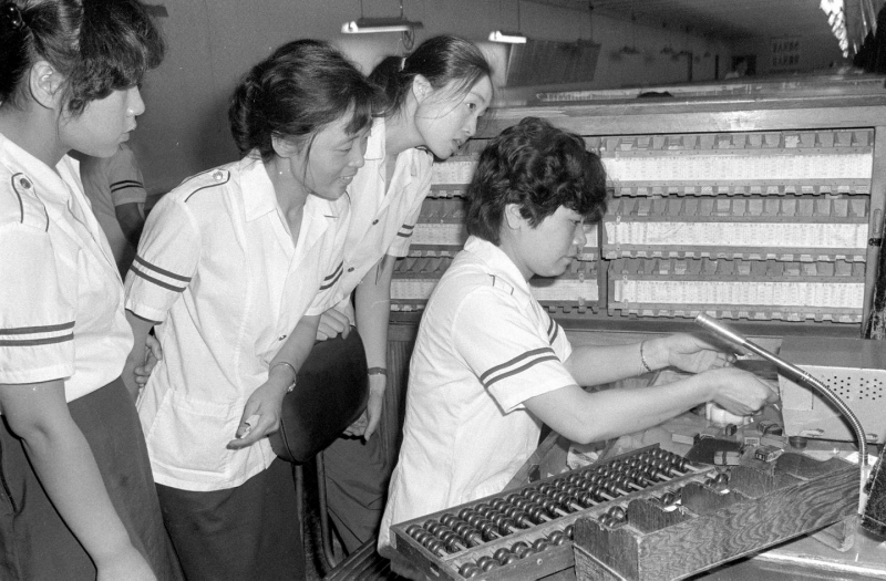 1986年、素早い発券方法を見て學(xué)ぶ切符販売係。（撮影?呉祖政）