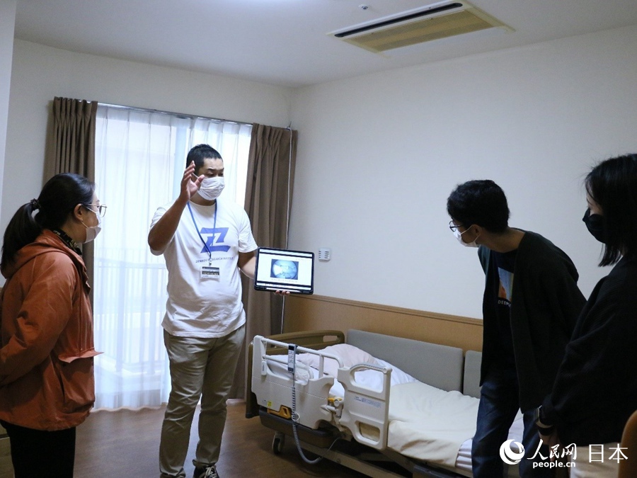 モニタリングシステムを紹介するスタッフ（撮影?許可）。